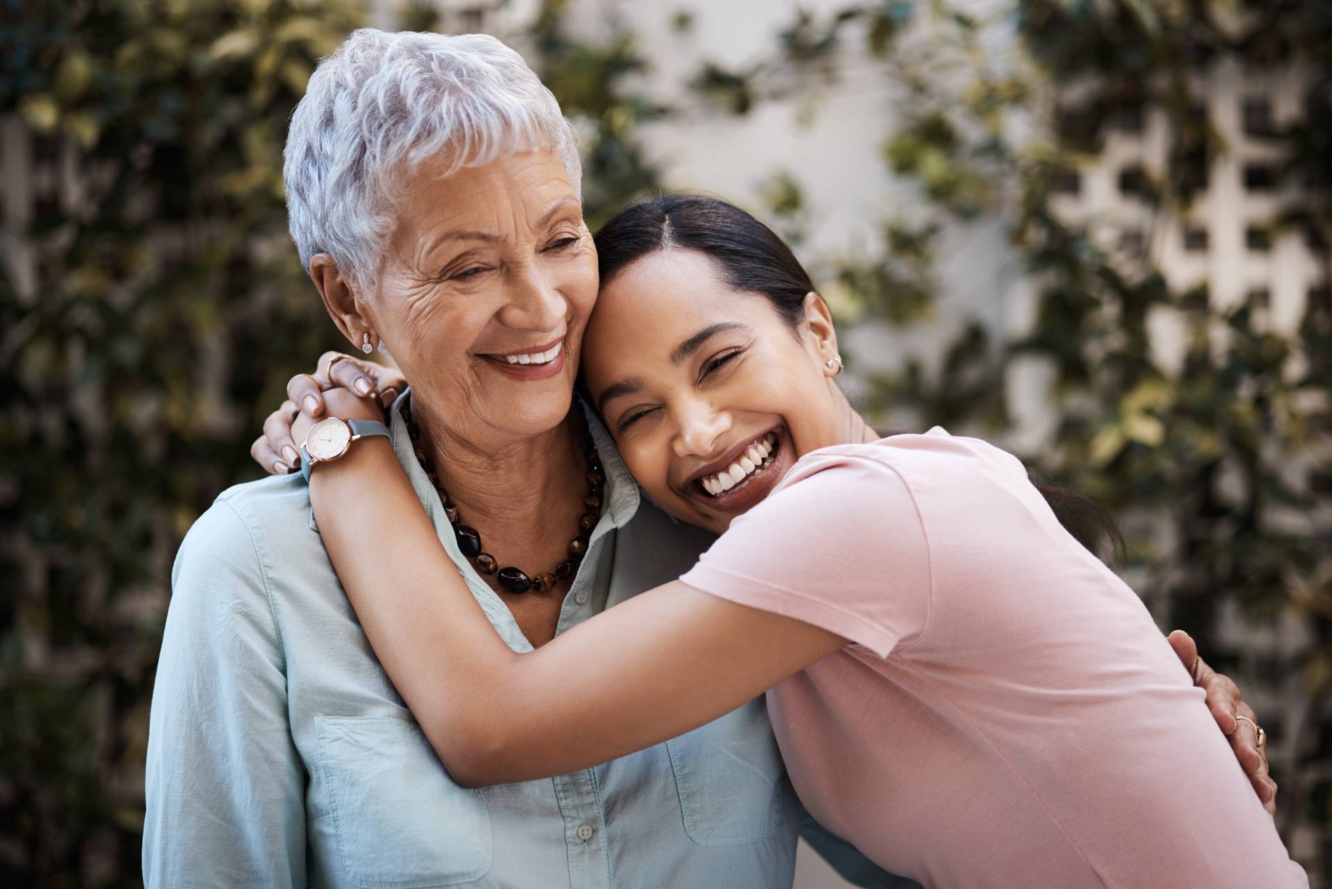 A daughter hugging her aging parent. 