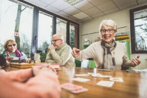 Elderly people with dementia smiling and engaging in activities.