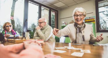 Elderly people with dementia smiling and engaging in activities.