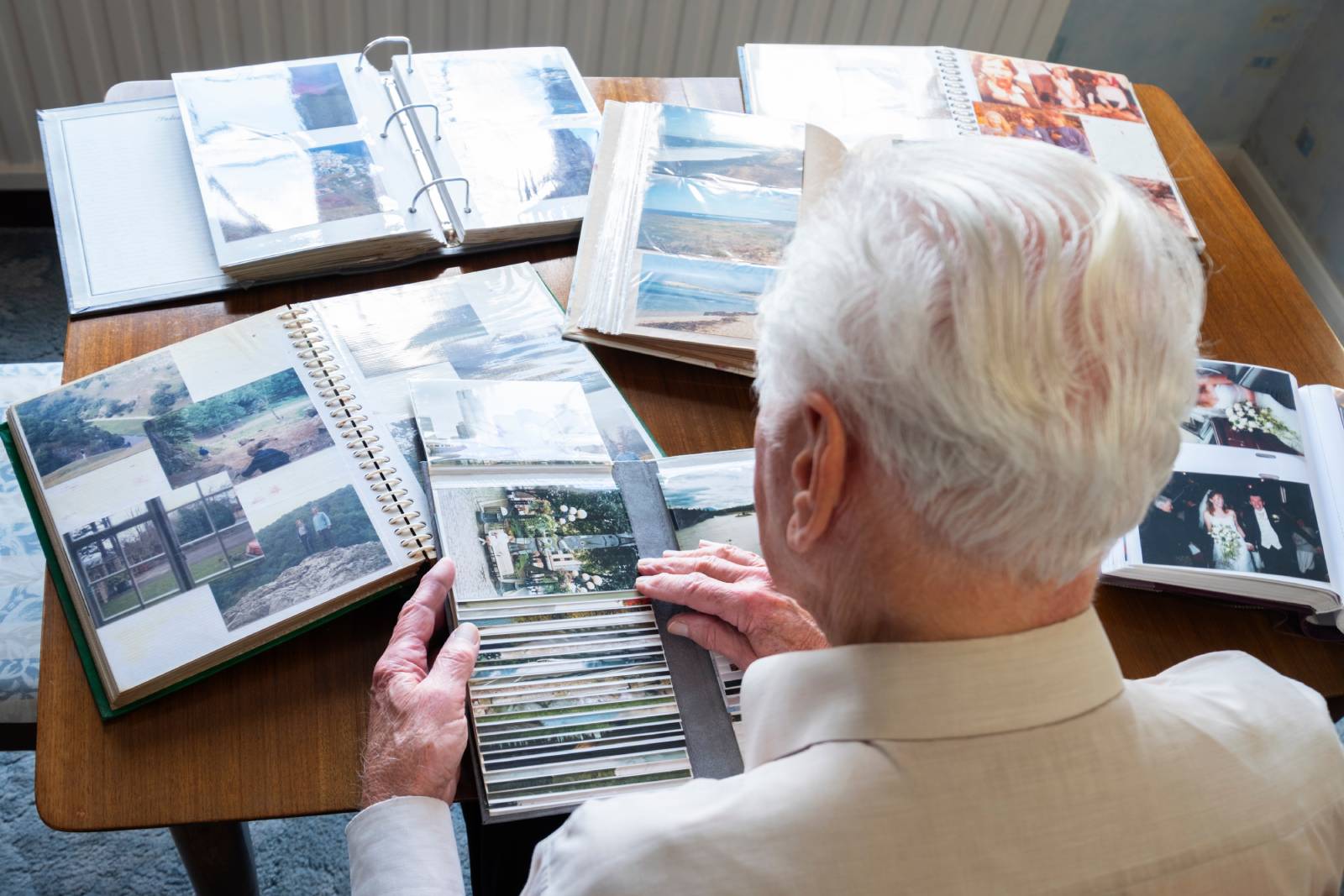 Senior with dementia looking through family photo albums.