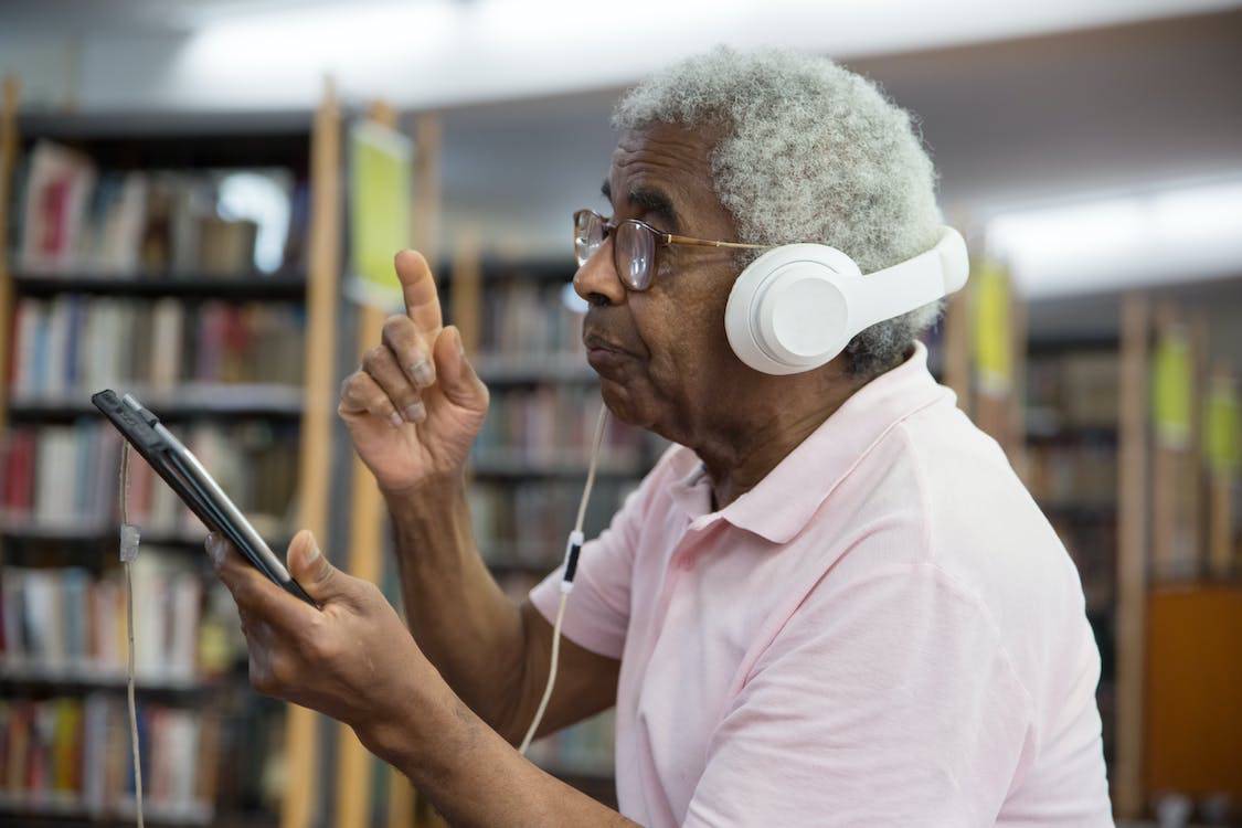 Elderly man with dementia listening to music on an iPad.