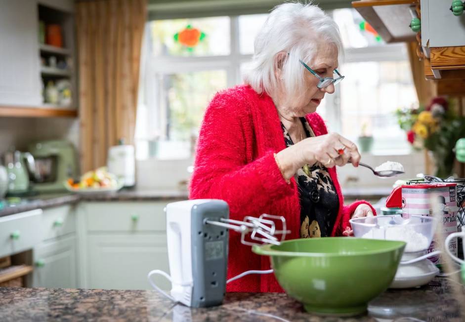 Elderly woman with dementia baking cookies.