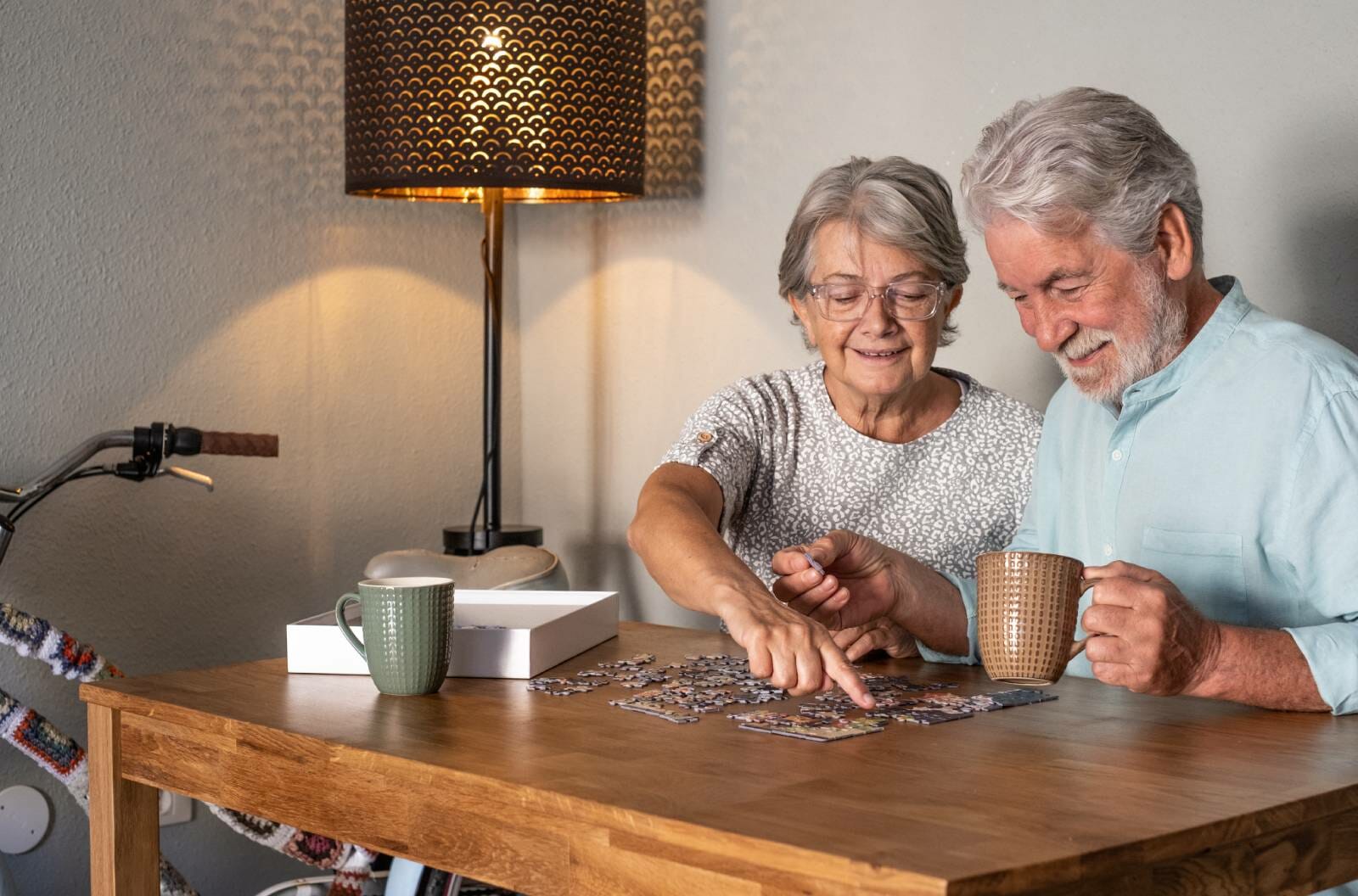 Elderly couple doing a jigsaw puzzle.